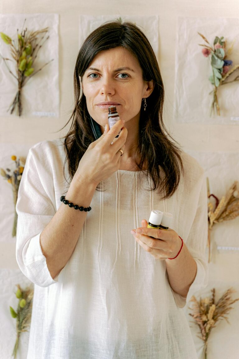 Adult woman indulging in aromatherapy, smelling essential oils indoors.